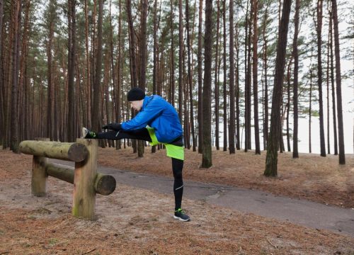 athlete-stretching-leg-forest_23-2147618077