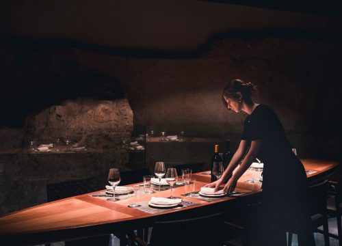 young-waitress-setting-table_23-2147830607